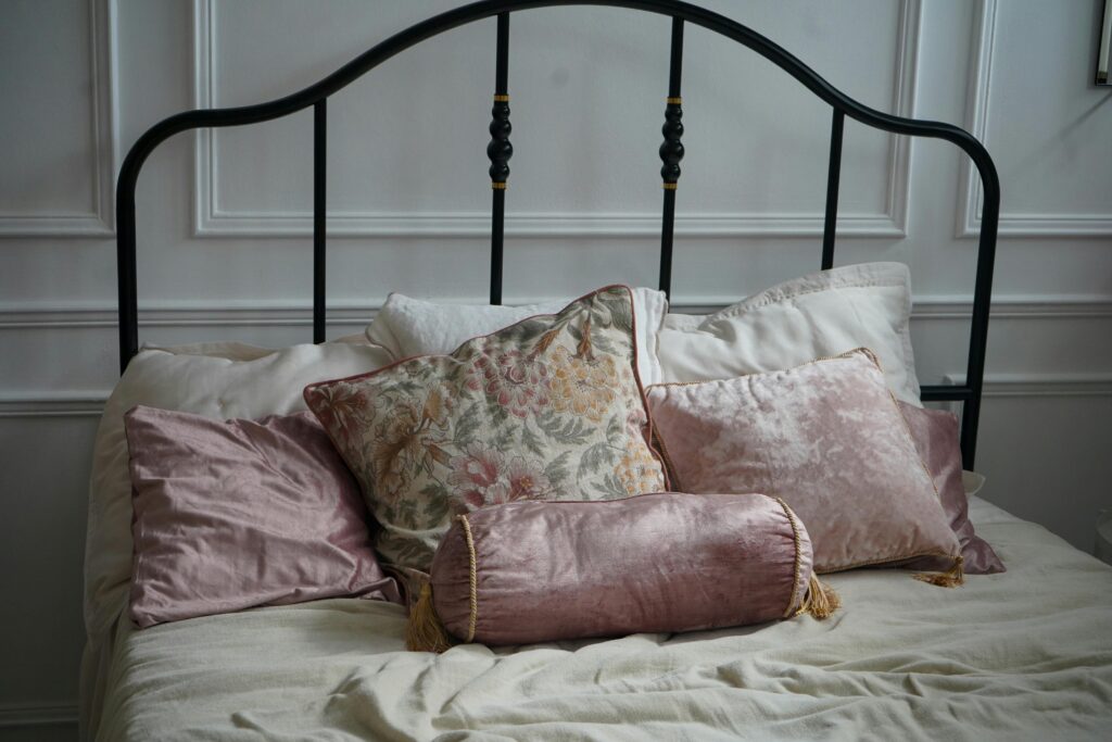 A cozy and elegant bedroom setup featuring decorative cushions and a classic bed.